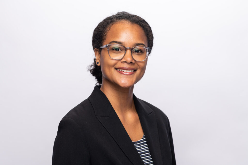 A professional headshot of a woman in glasses.