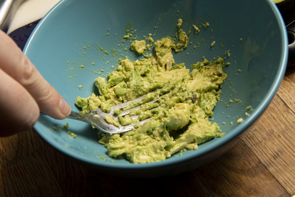 Avocado being mashed by a fork