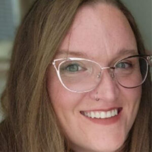 A headshot of Alyse Campbell, a white woman wearing glasses and smiling